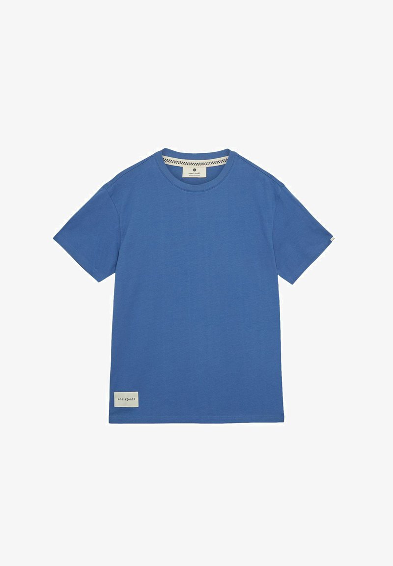 Sininen lyhythihainen T-paita pehmeästä puuvillasta, jossa on pyöreä kaula-aukko ja logopatchi helmassa. Tasainen pinta, normaali istuvuus.