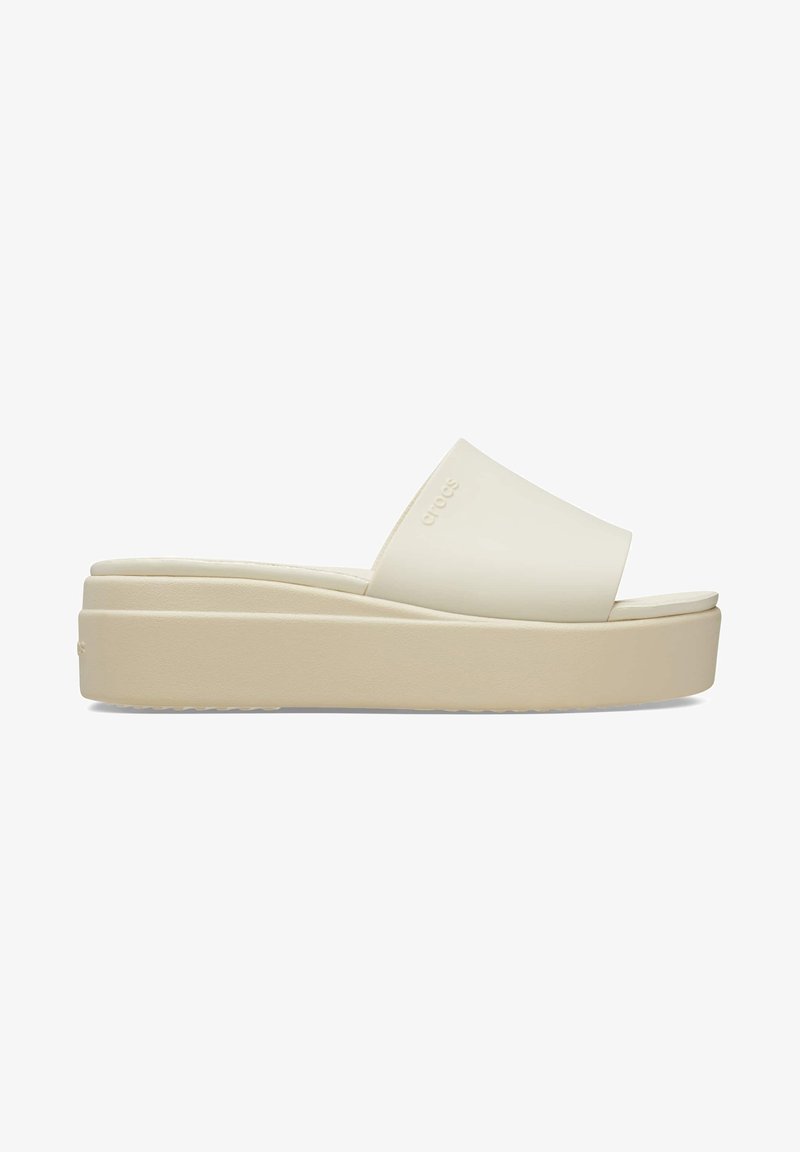 Sandale à plateforme beige avec une large sangle unique et une semelle épaisse, conçue pour un usage décontracté.