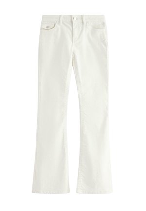 Hvide denimflarejeans med frontknap og lynlås, for- og baglommer, lagt fladt på en hvid baggrund.