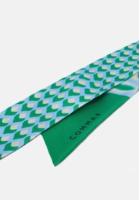 Zijden stropdas in lichtblauw met een geometrisch patroon in groen en beige; effen groene onderzijde met de merknaam "COMMA" in zwarte tekst.