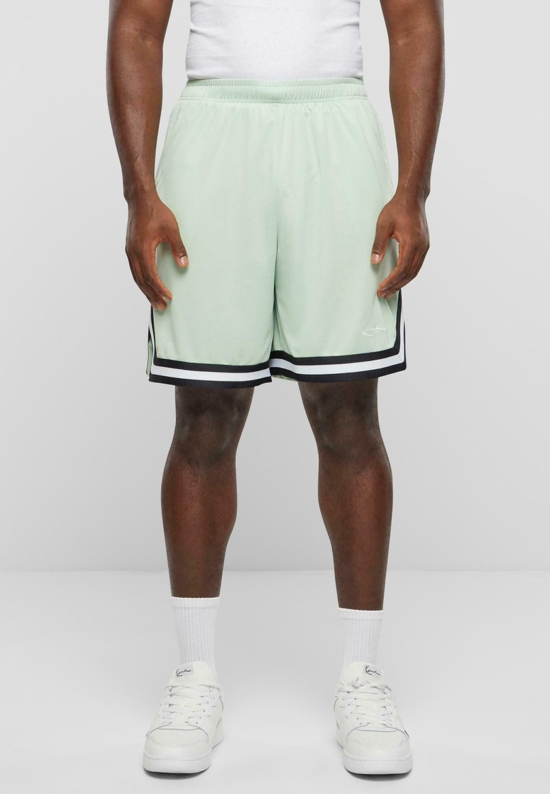 Shorts de sport vert clair avec des bandes latérales noires, en tissu respirant ; taille élastique pour le confort ; avec petit détail logo.