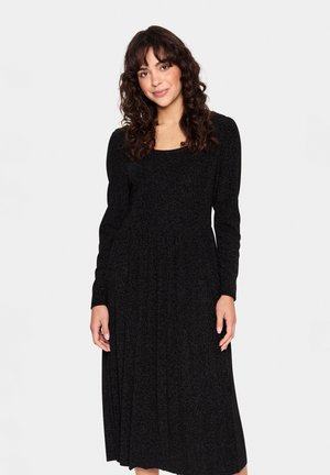 Black long-sleeve dress with a square neckline, pleated skirt, and a shimmering texture. Mid-calf length, fitted bodice, and flowing design.
