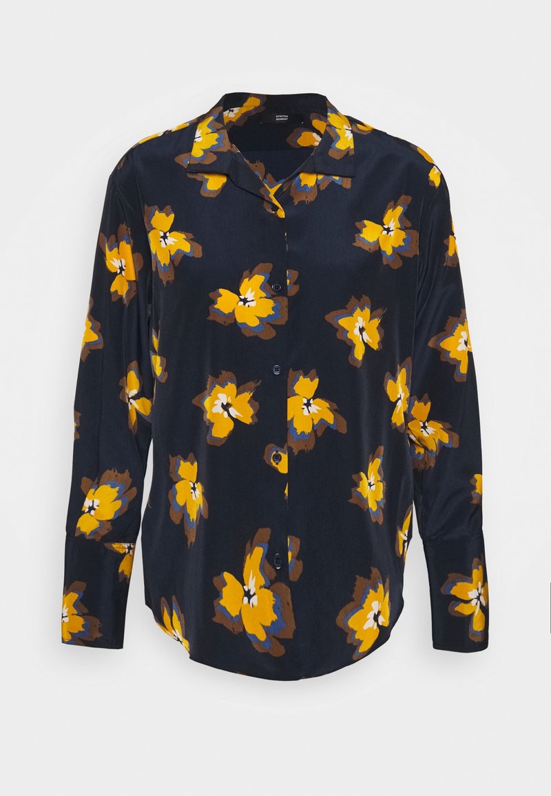 Chemise bleu marine avec motif floral jaune et marron, manches longues, boutons sur le devant et col. Tissu lisse et léger.