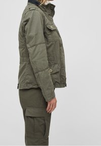 Olivgrön, blandning av bomull jacka med hög krage, framfickor och knappdetaljer. Texturerad yta med synliga sömnadsdetaljer.