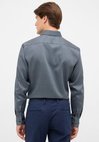 Donkerblauwe lange mouwen shirt met een geometrisch patroon in lichtblauw. Bevat een kraag en knoopmanchetten, gemaakt van gladde stof.