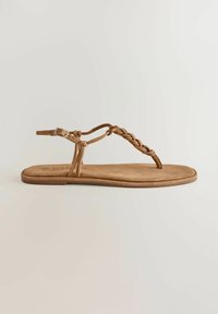Hnedá plochá sandála s pleteným remienkom, prackou okolo členka a pásikom medzi prstami, zobrazená na jednoduchom svetlom pozadí.