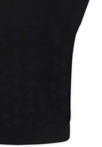 Zwart gebreid stof met een subtiel patroon van herhalende driehoekige vormen, met een ribbelmanchet aan de onderkant. Soepele textuur.