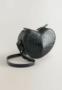 Borsa a tracolla a forma di cuore nera, realizzata in pelle sintetica di coccodrillo. Dotata di zip dorata e tracolla regolabile. Texture liscia con motivo stampato.