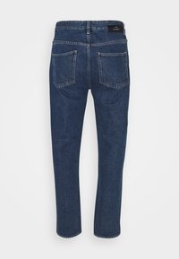 Vaqueros de mezclilla azul oscuro con diseño de pierna recta, cinco bolsillos y textura suave. La cintura presenta una etiqueta de la marca en la parte trasera.