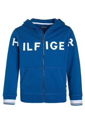 Sudadera con capucha azul de cremallera completa con letras blancas en bloque que forman "HILFIGER" en el pecho y las mangas, bolsillos frontales y puños con franjas blancas.