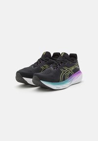 Zwarte sportieve schoenen met een gestructureerde bovenkant, voorzien van gele accenten, paarse veters en een gradient zool van turquoise naar wit.