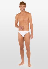 Witte katoenen slips met een low-rise ontwerp, zachte textuur en een gladde afwerking. De tailleband bevat een subtiele logodetail.