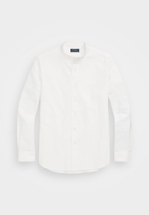 Chemise blanche à manches longues boutonnée avec col mandarin posée à plat, avec de petits boutons blancs et une étiquette Polo Ralph Lauren à l'intérieur du col.