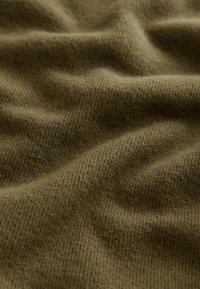 Tissu vert olive doux avec une fine texture côtelée en tricot et de légers plis créant des ombres subtiles.