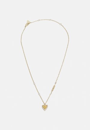 Delikatny naszyjnik z łańcuszka ze złota z małymi koralikami i zawieszką w kształcie serca z złotym środkiem otoczonym przez przezroczyste kamienie.