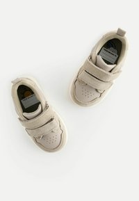Beige Sneaker mit Klettverschluss, aus Leder und Wildleder, runde Zehenpartie, perforierte Details und eine bedruckte Innensohle mit einer Cartoon-Sonne.