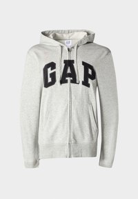 Grauer Sweatshirt mit Reißverschluss aus Baumwollmischgewebe. Verfügt über große schwarze "GAP"-Schriftzüge auf der Brust, einen Kapuzenzug und Vordertaschen.