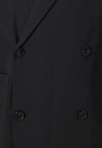 Schwarzer doppelt-geknöpfter Blazer mit glatter Textur, zwei schwarzen Knöpfen und zwei Seitentaschen. Maßgeschneidertes Design mit aufschlagbaren Revers.