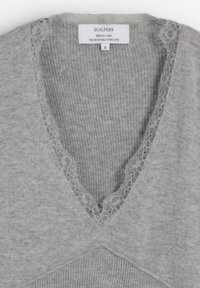 Suéter gris claro con cuello en V y ribete de encaje a lo largo del escote y textura acanalada. Etiqueta adherida en la parte posterior indica la marca y la talla.