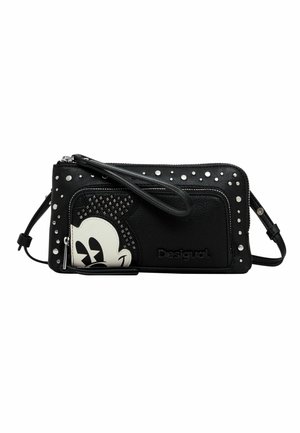 Schwarze Leder-Crossbody-Tasche mit Nietenakzenten, strukturiertem Design und einem Motiv eines weißen Cartoon-Charakters. Reißverschlussverschluss mit Handgelenkriemen.