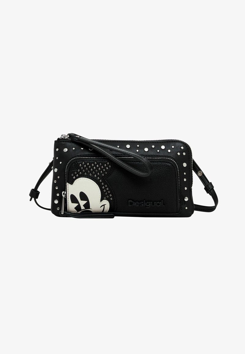 Bandolera de cuero negro con acentos de tachuelas, un diseño texturizado y un motivo de personaje de dibujos animados en blanco. Cierre de cremallera con una correa para la muñeca.