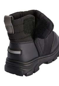 Botte noire robuste à la cheville avec semelle épaisse à crampons, col rembourré, bande réfléchissante au talon et sangle à fermeture auto-agrippante réglable.