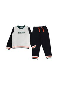 Completo felpa e pantaloni. Parte superiore bianca con maniche nere, scollo verde e dettagli a strisce multicolori. Pantaloni neri con cordino arancione.