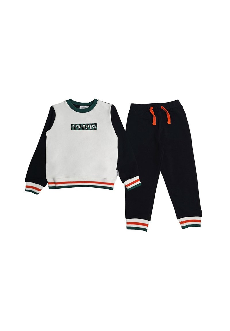 Completo felpa e pantaloni. Parte superiore bianca con maniche nere, scollo verde e dettagli a strisce multicolori. Pantaloni neri con cordino arancione.