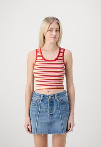 Top court à rayures rouges et jaunes avec un décollet�é arrondi et une texture côtelée, associé à une jupe en denim mini taille haute.