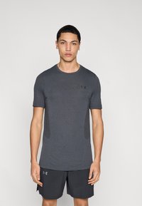 Γκρι αθλητική κοντομάνικη μπλούζα με υφή υφάσματος. Διαθέτει διακριτικό λογότυπο στο στήθος και εφαρμόζει στενά στο σώμα.