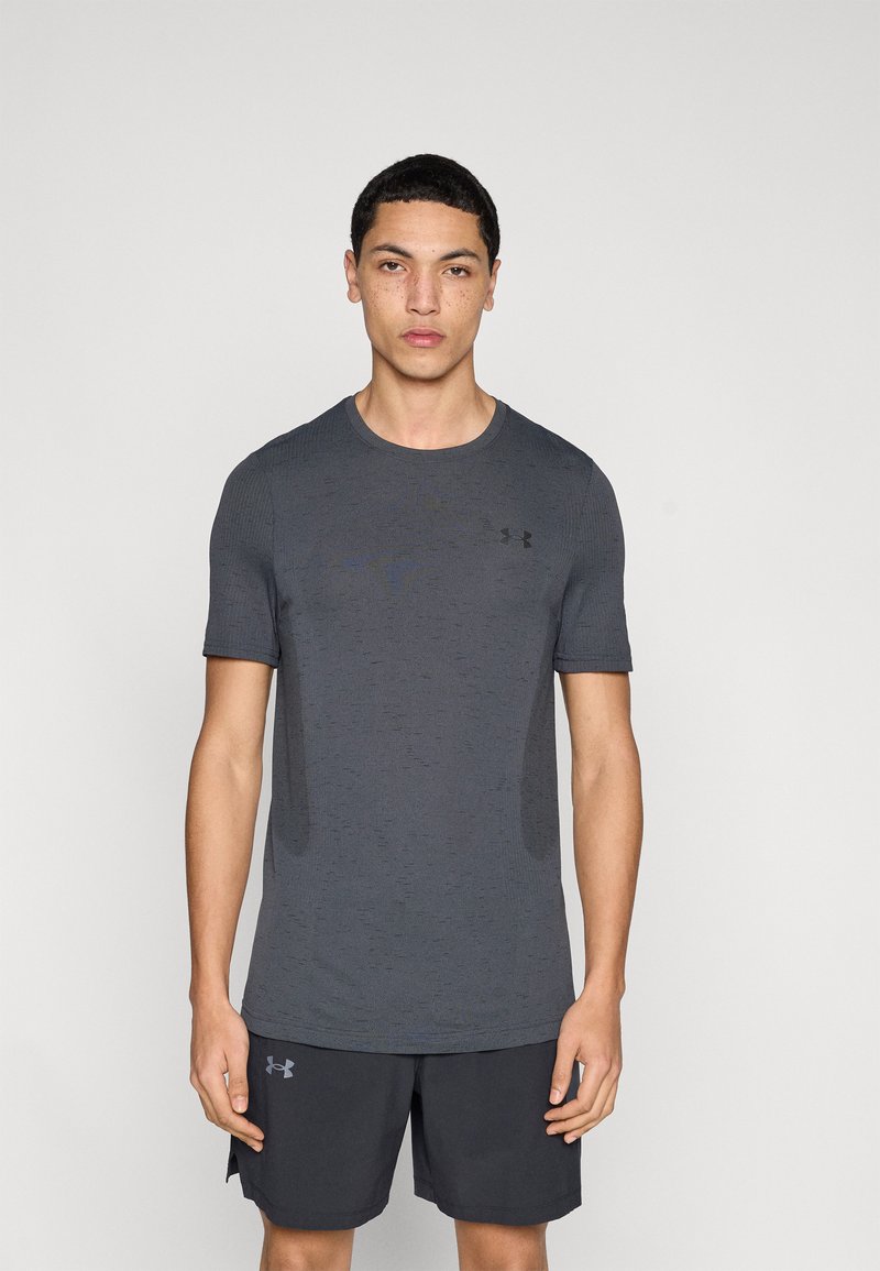 Γκρι αθλητική κοντομάνικη μπλούζα με υφή υφάσματος. Διαθέτει διακριτικό λογότυπο στο στήθος και εφαρμόζει στενά στο σώμα.