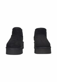 Stivaletti neri in suede con suole spesse, punte arrotondate e una piattaforma alta, mostrati frontalmente su uno sfondo bianco.