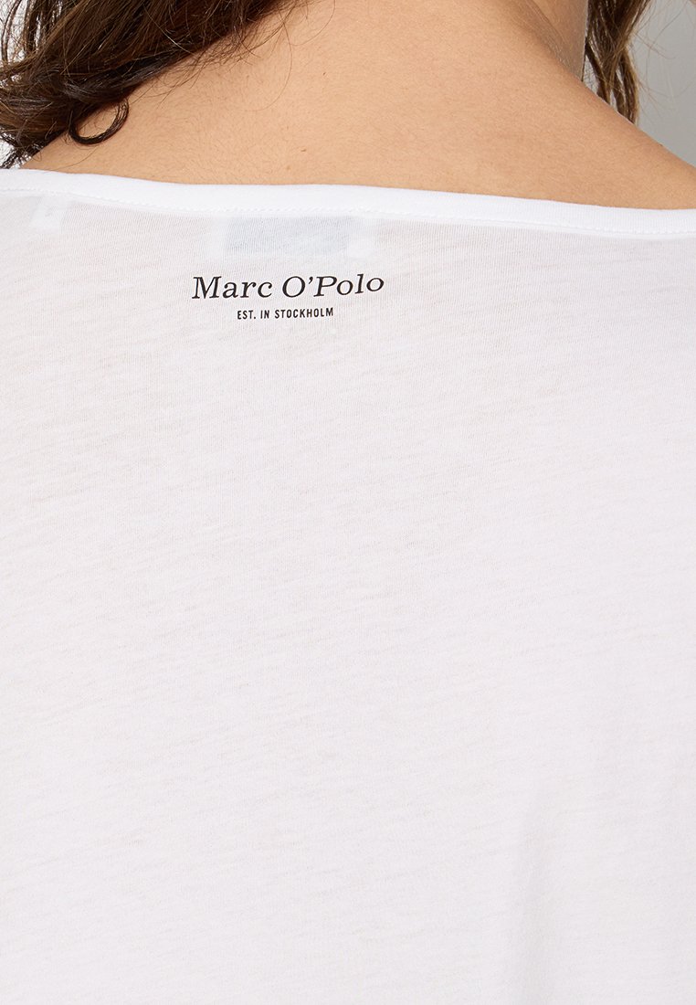 Biała bawełniana koszulka z luźnym fasonem, szerokim dekoltem i czarnym nadrukiem na plecach: "Marc O’Polo EST. W STOCKHOLM."