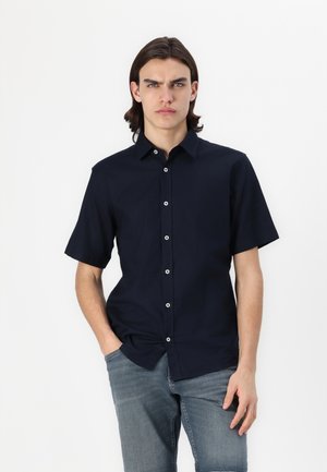 Short-sleeved, navy blue button-up shirt made from cotton. Features a classic collar and white contrast buttons down the front.