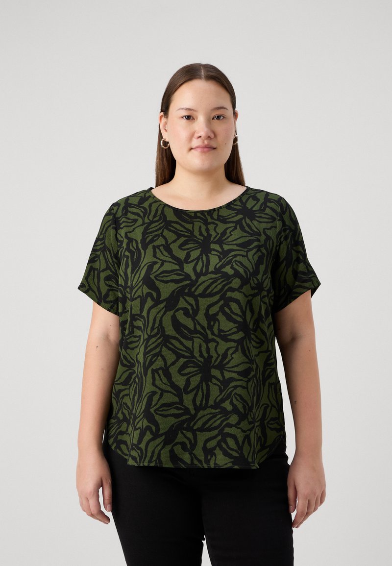 Grön kortärmad topp med svart bladmönster, rund halsringning, avslappnad passform, textil med struktur, kombinerad med svarta byxor.