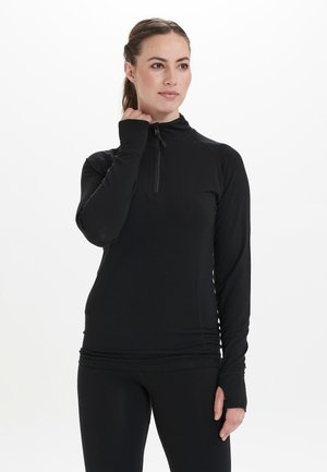 Black long-sleeve athletic top with a half-zip collar, tailored fit, and thumbholes at cuffs, made from a smooth, stretchy fabric.