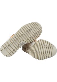Sneaker soles with a textured, ridged pattern. Cream color with light gray accents. Features manufacturer logo and model number on the side.