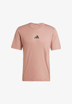 T-shirt sportivo rosa chiaro con un motivo testurizzato sulla parte anteriore superiore e un logo nero. Maniche corte e scollo rotondo. Tessuto morbido.