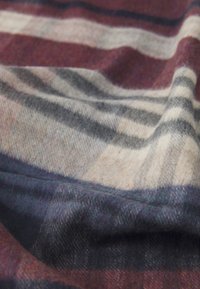 Plaid wool blanket with shades of burgundy, gray, and cream. Soft texture with a warm, inviting pattern and draped appearance.
