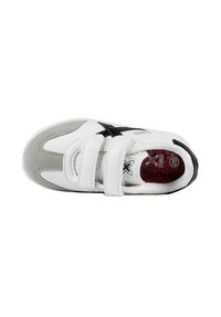 Scarpa sportiva bianca con accenti in suede grigio e strisce nere. Presenta due cinturini in velcro e una soletta testurizzata rossa. Suola piatta nera.
