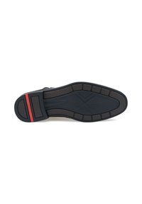 Semelle de chaussure en caoutchouc noire avec un motif texturé, présentant un accent rouge au niveau du talon et une section centrale lisse.