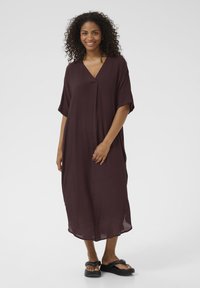 Abito bordeaux a V con maniche corte, vestibilità comoda e lunghezza media fino al polpaccio. Realizzato in tessuto leggero con una texture liscia.