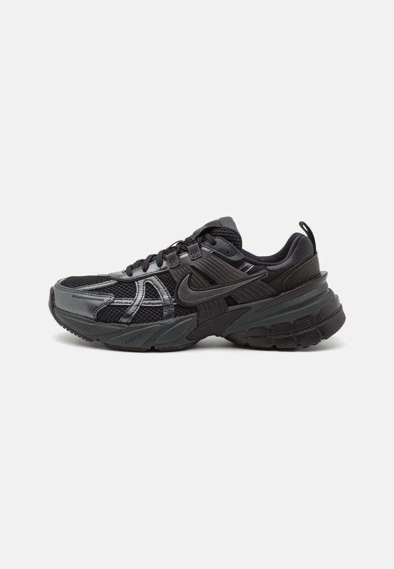 Scarpa sportiva nera realizzata con una combinazione di materiali in rete e sintetici, con accenti testurizzati e una suola spessa e imbottita con un profilo robusto.