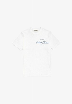 T-shirt blanc col rond avec texte bleu "welcome to Saint Tropez ÉTÉ 1984" sur la poitrine gauche, manches courtes, et une étiquette de la marque Frilivin à l'intérieur du col.