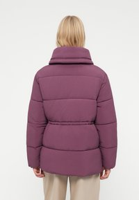 Paarse pufferjack met een hoge kraag, gekatoeide ontwerp en een ceintuursluiting. Heeft een gladde textuur en een losse pasvorm, geschikt voor koud weer.