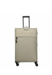 Maleta rígida beige con estrías horizontales, asa telescópica extendida, bolsillo delantero con cremallera y cuatro ruedas giratorias.