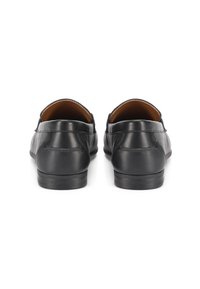 Mocasines de cuero negro con una textura suave, detalles de costura sutil y suelas planas. Diseño minimalista con puntera redonda y tacón bajo.