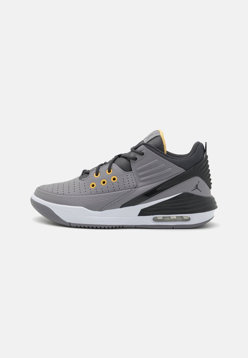 Chaussure de sport basse grise et noire avec œillets jaunes, semelle blanche, coussin d'air et logo Jumpman noir sur le talon.