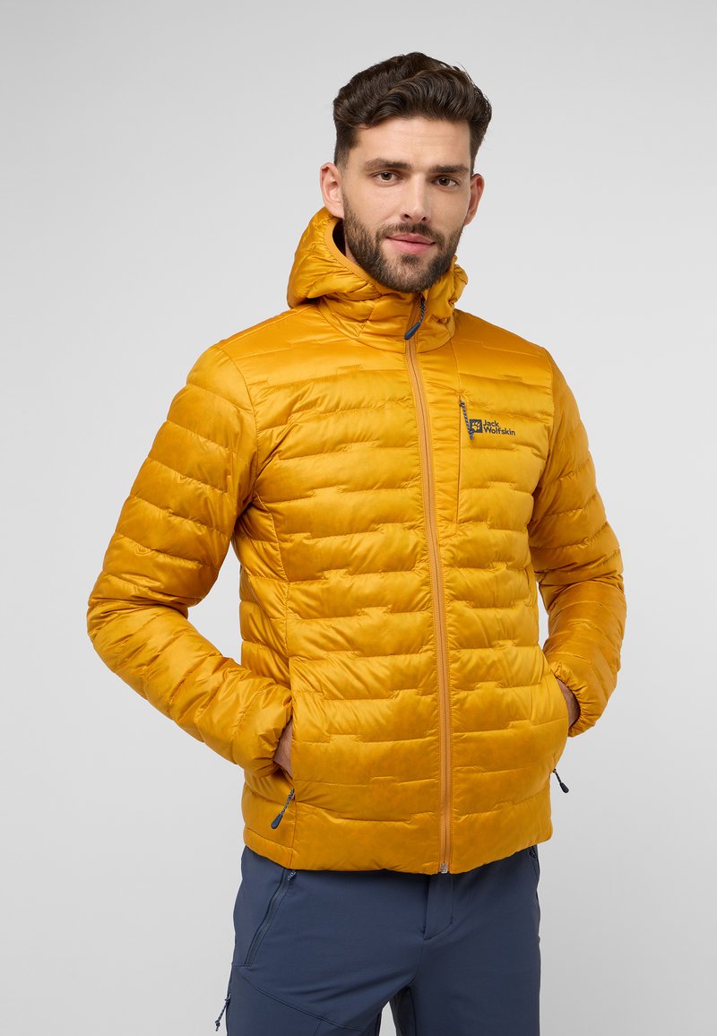 Veste rembourrée jaune avec fermeture éclair sur le devant, capuche et logo sur la poitrine. Comprend un design matelassé cousu, des poignets élastiques et des poches.