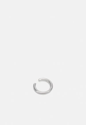 Anneau ouvert en argent lisse avec un design simple de bande arrondie sur un fond uni gris clair.